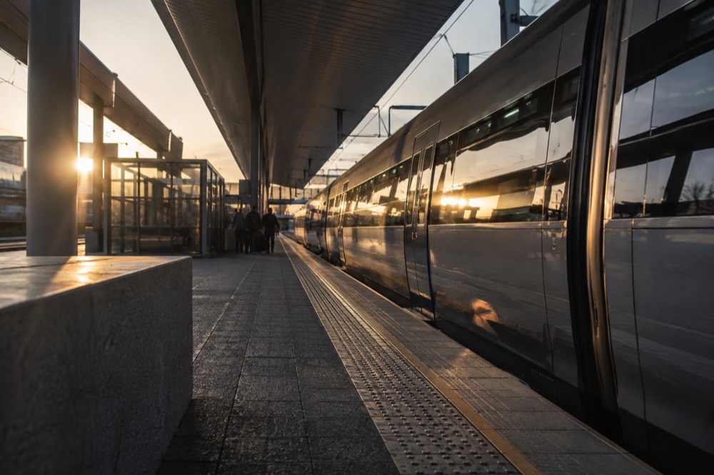 Train platform at an airport station with a sleek express train waiting