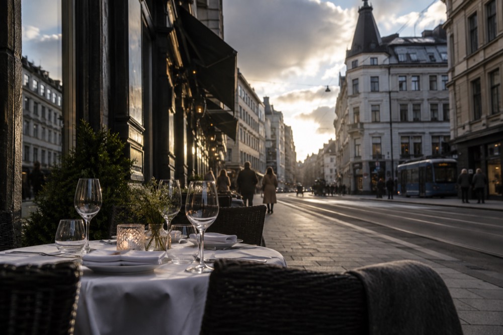 Elegant restaurant table set for dinner with wine glasses in soft evening light