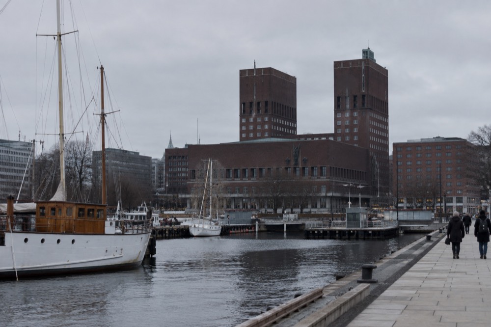 Oslo harbor front with the City Hall tower and moored boats
