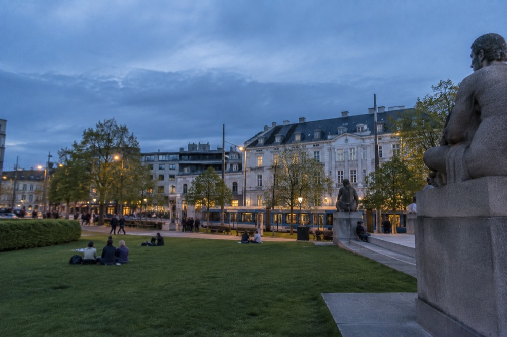 Wide lawn with people relaxing beside carved stone sculptures