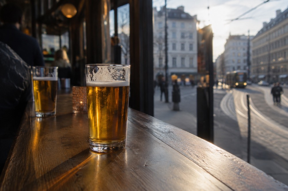Glasses of lager on a wooden bar counter in an Oslo bar