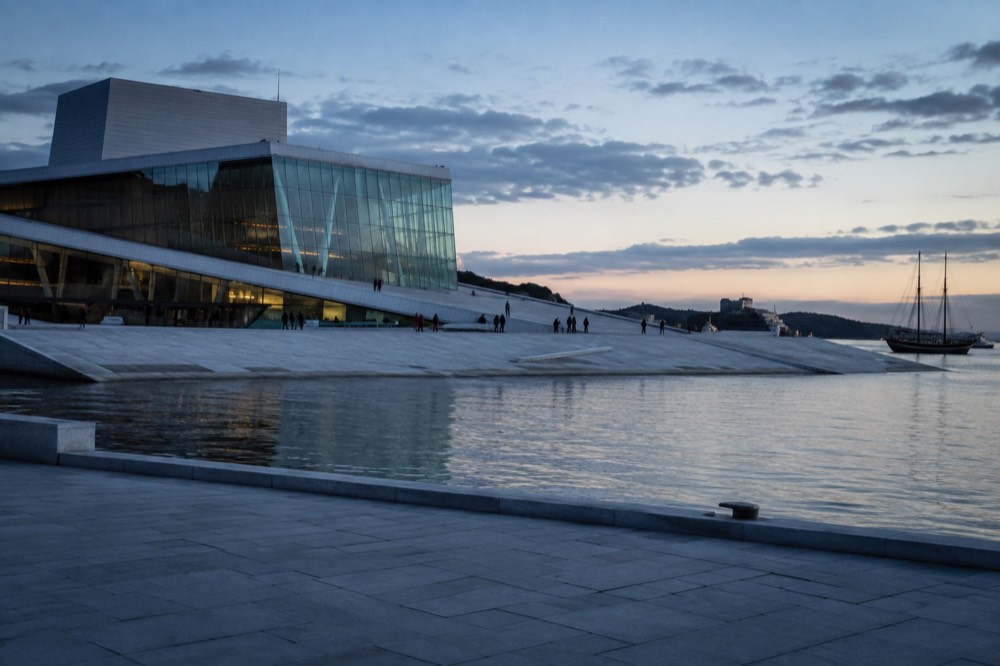 Oslo Opera House waterfront with the fjord and moored boats behind it
