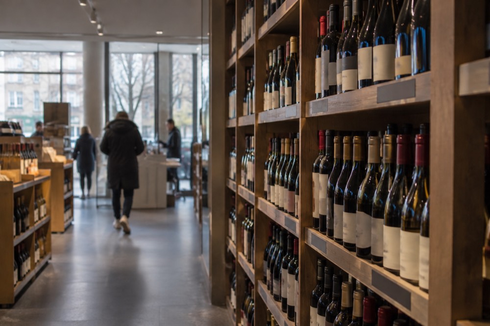 Bottles lined up on wooden shelves inside a Vinmonopolet shop in Oslo