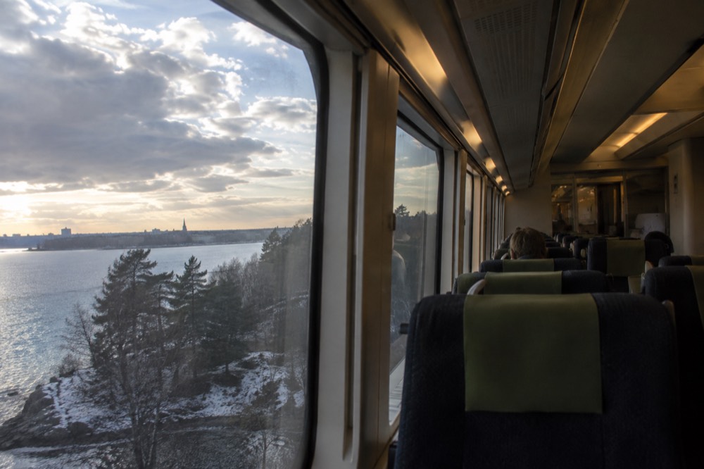 A quiet intercity train interior with reserved seats and large windows
