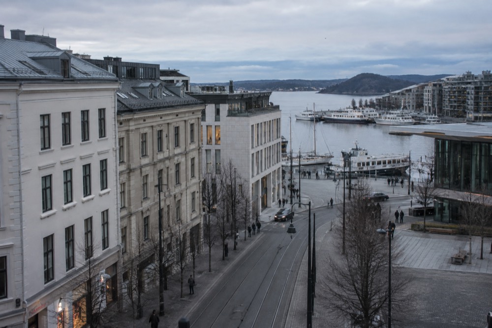 Oslo fjord waterfront with moored boats and modern buildings under a soft sky
