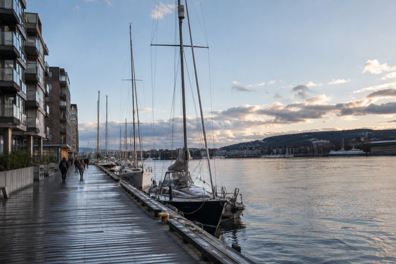 Aker Brygge waterfront in Oslo with moored boats and apartment buildings along the fjord