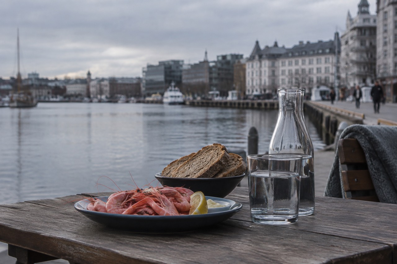 Fresh shrimp and bread served on a wooden table beside the Oslofjord