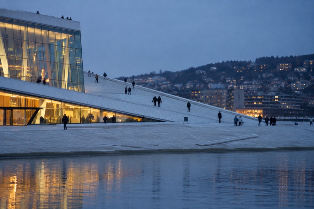 Sloping marble roof of the Oslo Opera House rising from the Bjørvika waterfront