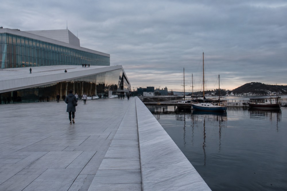 Oslo Opera House waterfront with moored boats on a calm evening
