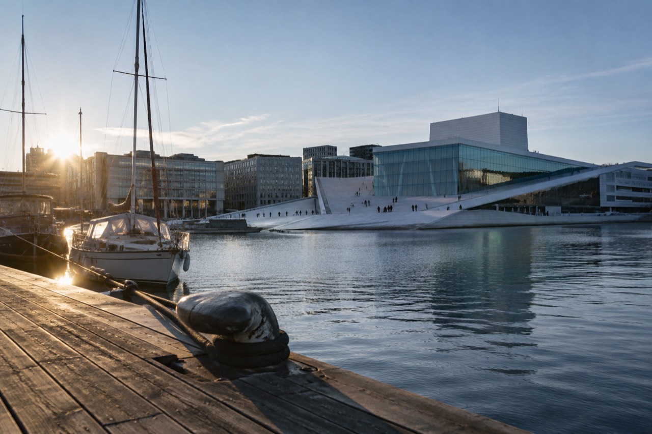 Oslo waterfront with the opera house roof and moored boats on a calm fjord