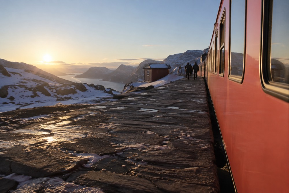 Red railway carriages at a mountain station above the tree line in Norway