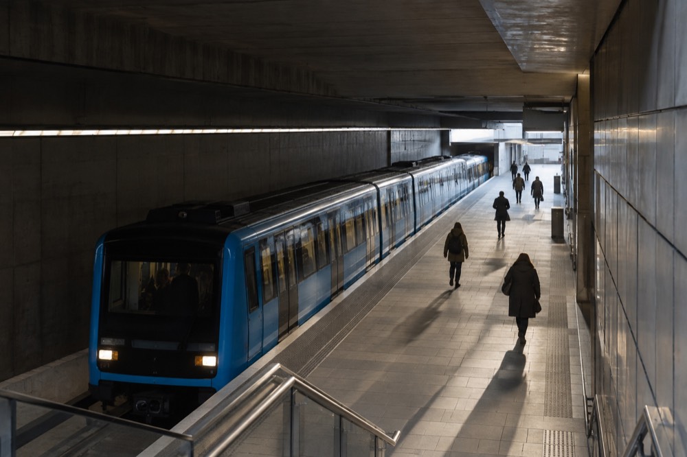 A metro platform in Oslo with a blue train waiting at an underground station