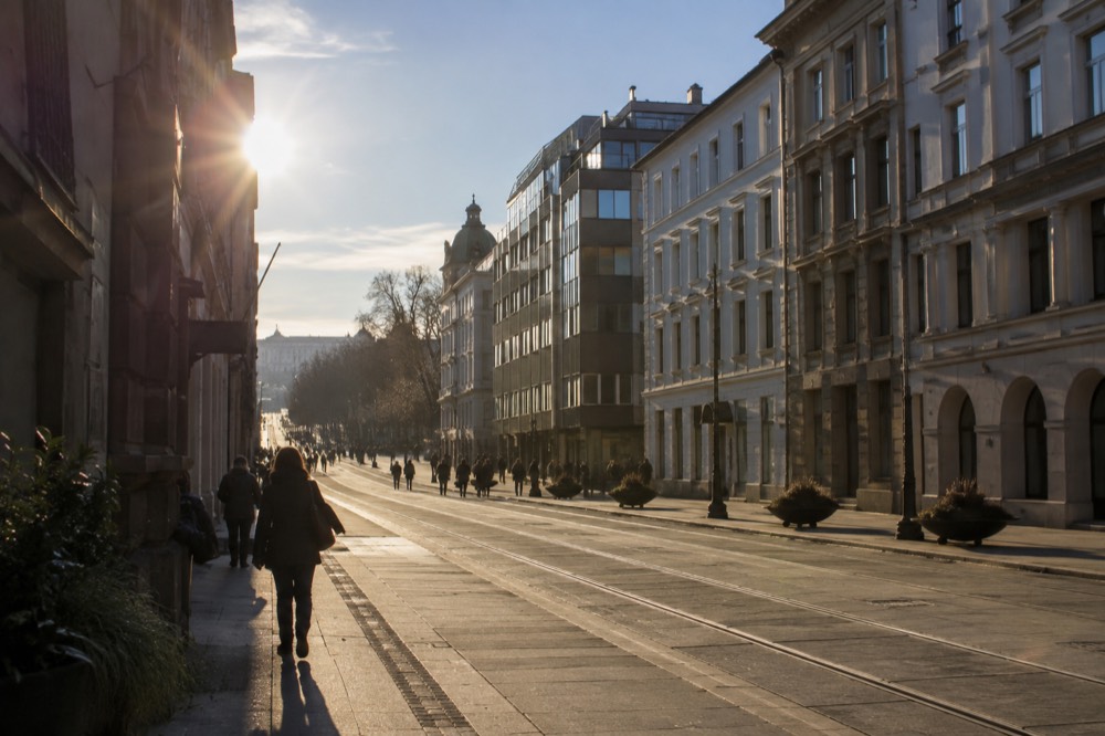 Wide pedestrian avenue with tram tracks and historic buildings on both sides