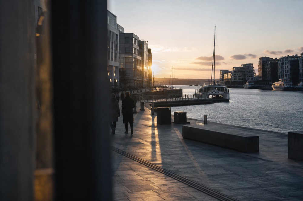 Harbor waterfront with modern buildings and moored boats at dusk