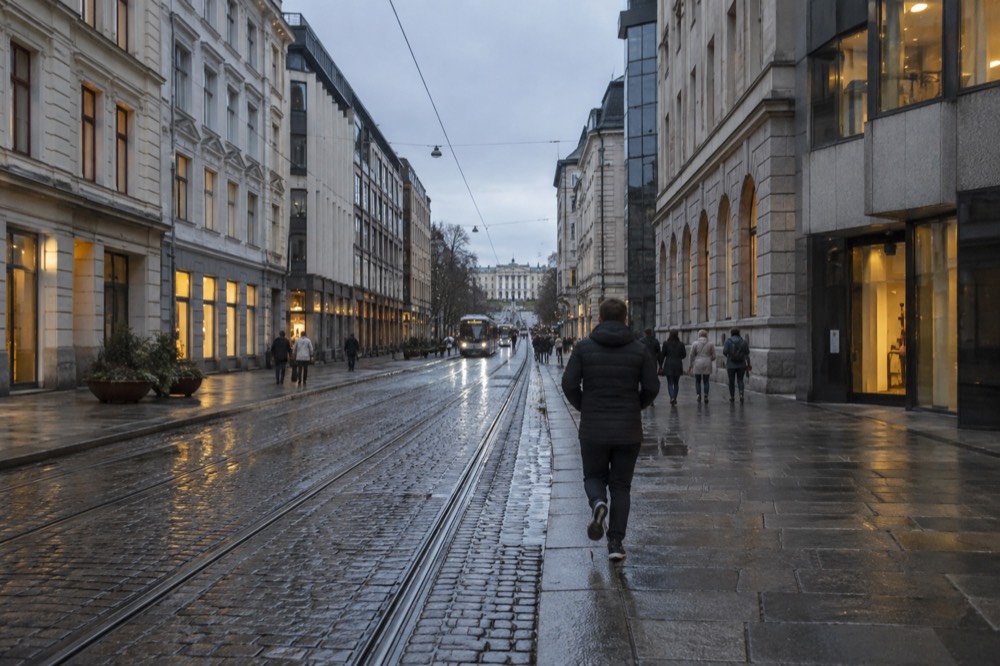 Wet cobblestone street in central Oslo reflecting grey evening light