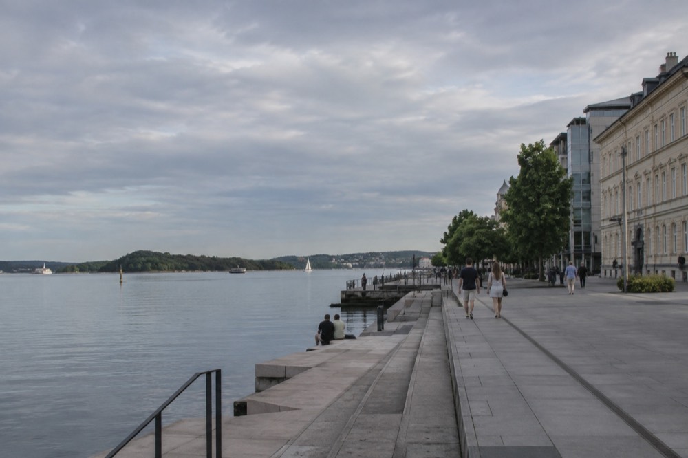Small islands with forest and summer houses seen across calm fjord water