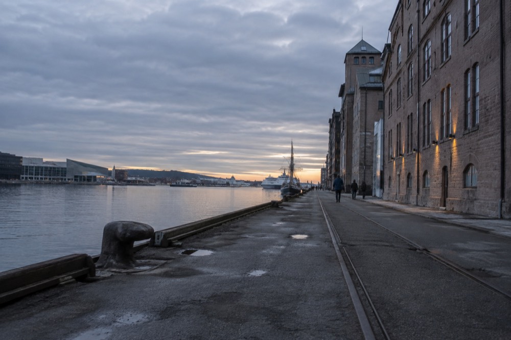 Old harbor buildings along the Oslofjord waterfront at dusk