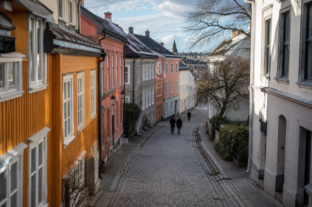 Cobblestone street with colorful old wooden and brick townhouses in central Oslo