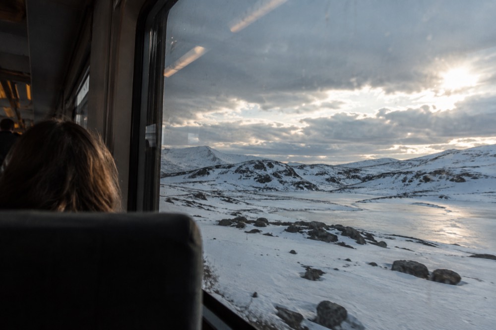 A passenger train crossing a high mountain plateau in Norway