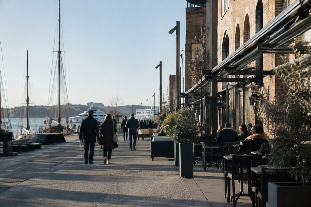 Brick former shipyard buildings along the Aker Brygge waterfront with outdoor seating