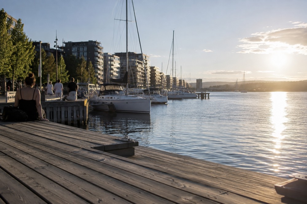 Long summer evening light over the Aker Brygge waterfront with boats at anchor