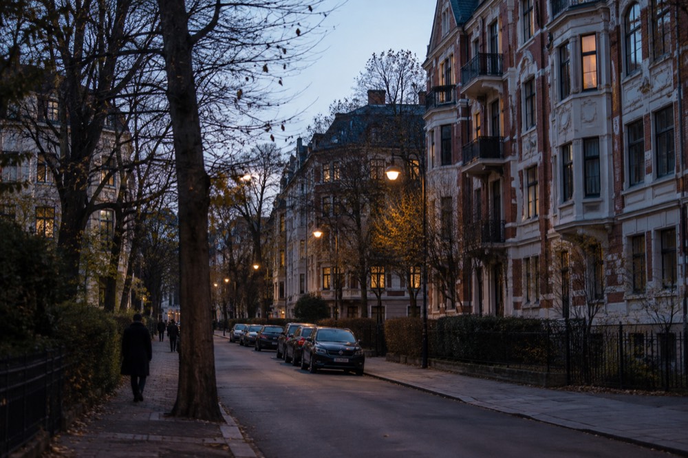 Grand brick apartment buildings with ornate facades on a quiet Frogner street