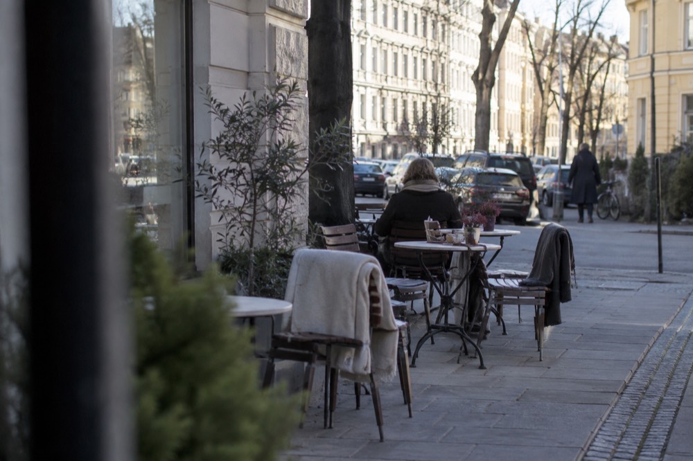 Café tables and chairs outside a bakery on a Frogner street corner