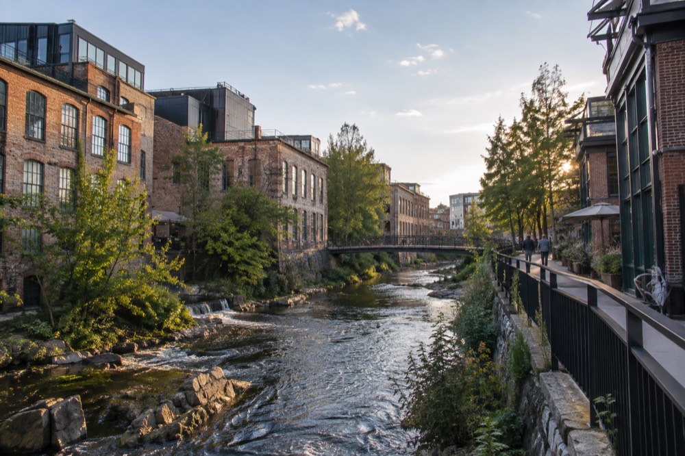 The Akerselva river flowing between old brick mill buildings in central Oslo