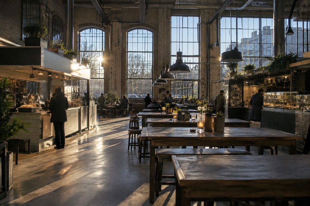 Food counters and shared tables inside a converted brick industrial hall