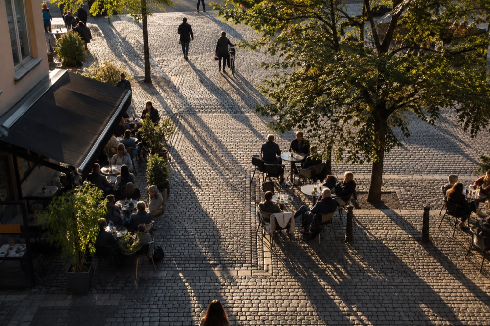 Outdoor cafe tables on a city square in warm evening light