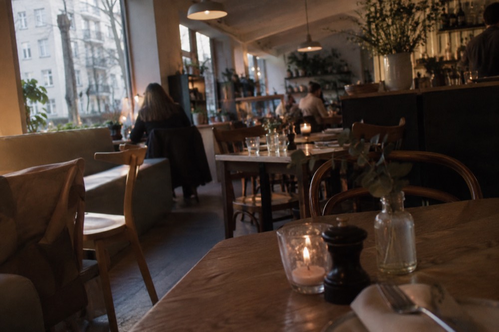 Small neighborhood bistro interior with wooden tables and evening light