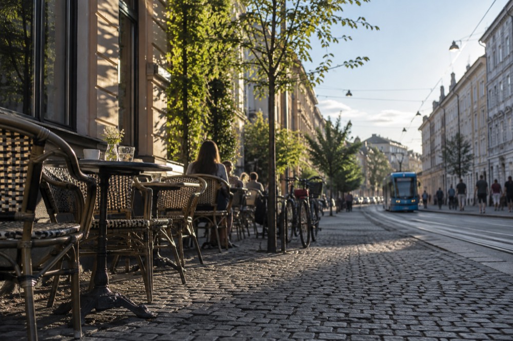 Café tables and bicycles on a cobblestone street in Grünerløkka