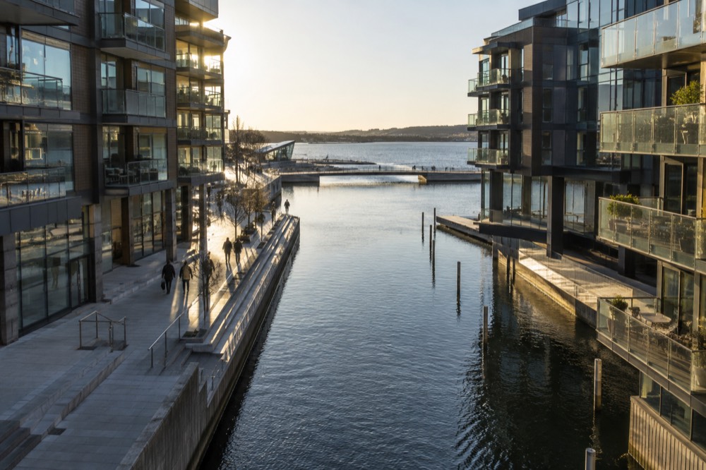 Modern apartment buildings and a canal walkway in the Tjuvholmen district