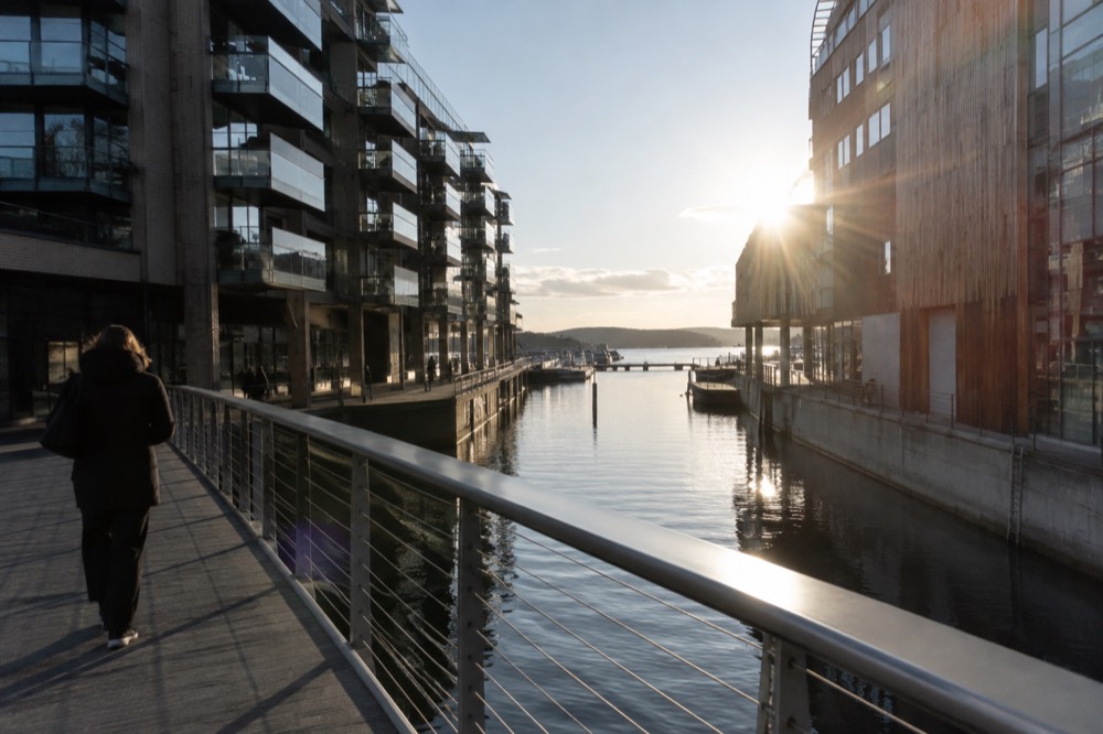Footbridge over a narrow canal between modern buildings at Tjuvholmen