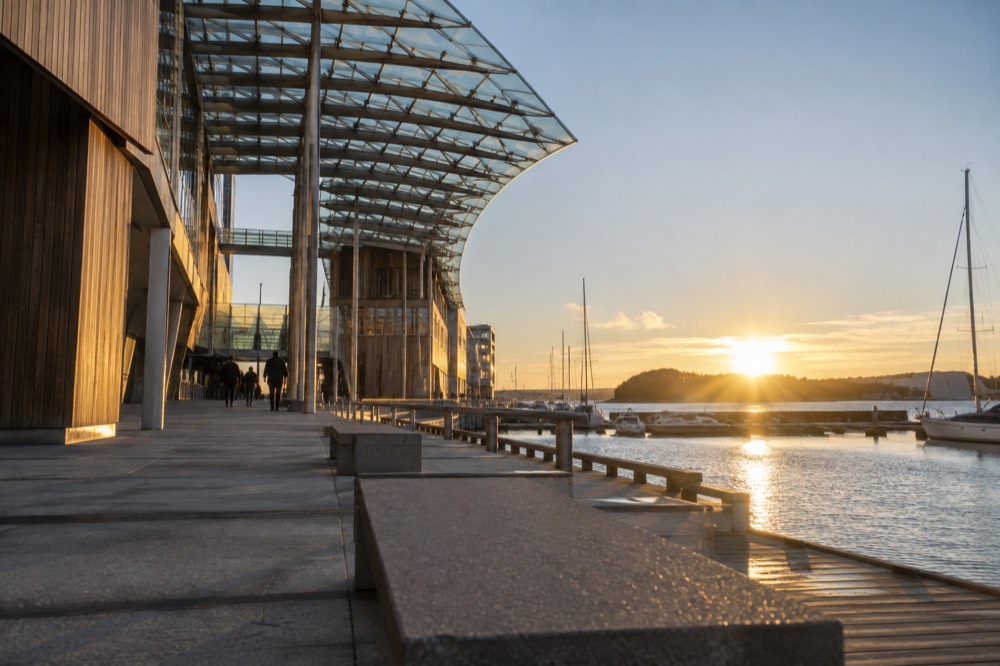 Waterfront path with the museum building and moored boats in the background