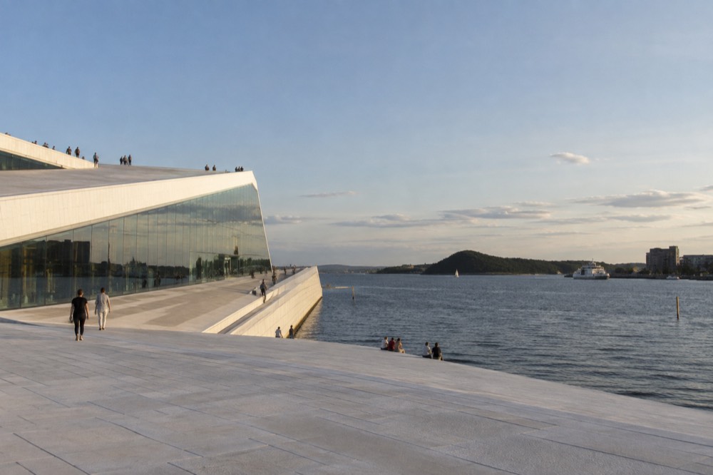 Angular white marble roof of the Oslo Opera House sloping down to the fjord
