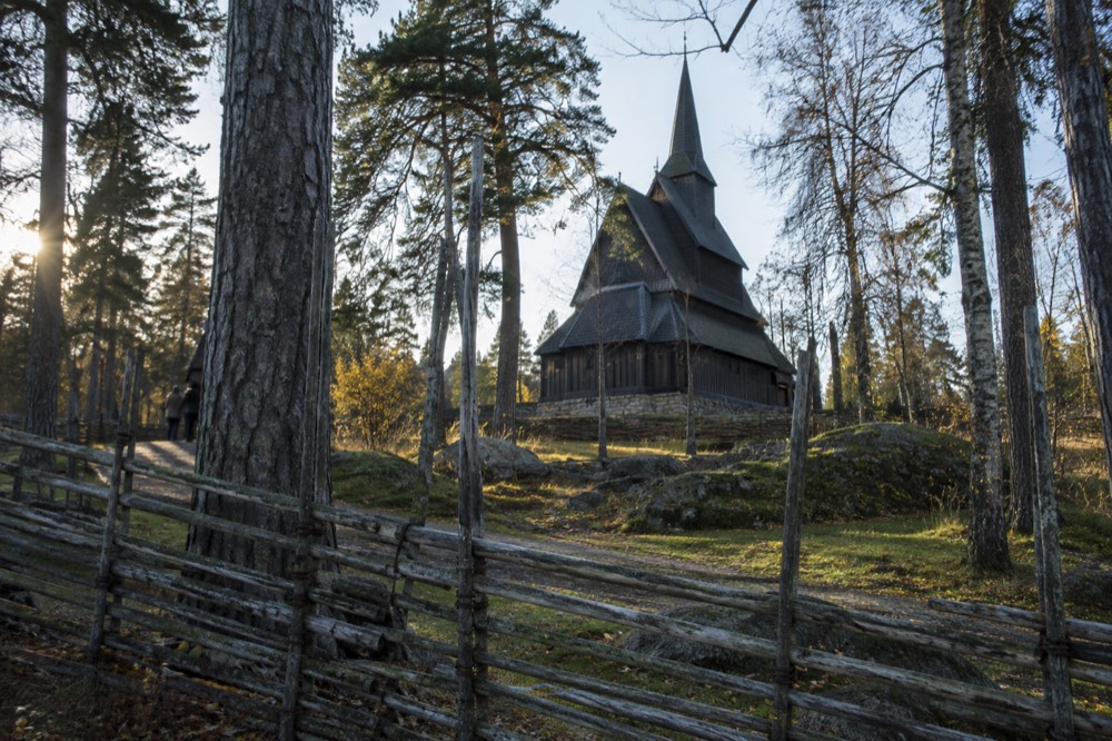 Carved wooden portal and dark timber walls of a stave church