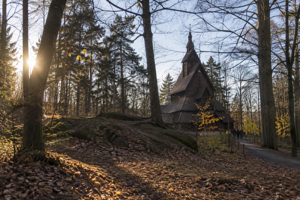 Interior of a dark timber stave church with carved wooden details
