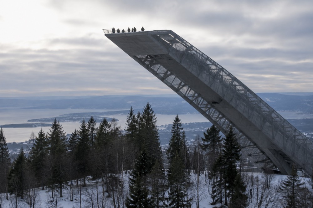 Visitors on the observation walkway at the top of the Holmenkollen jump tower above the forest