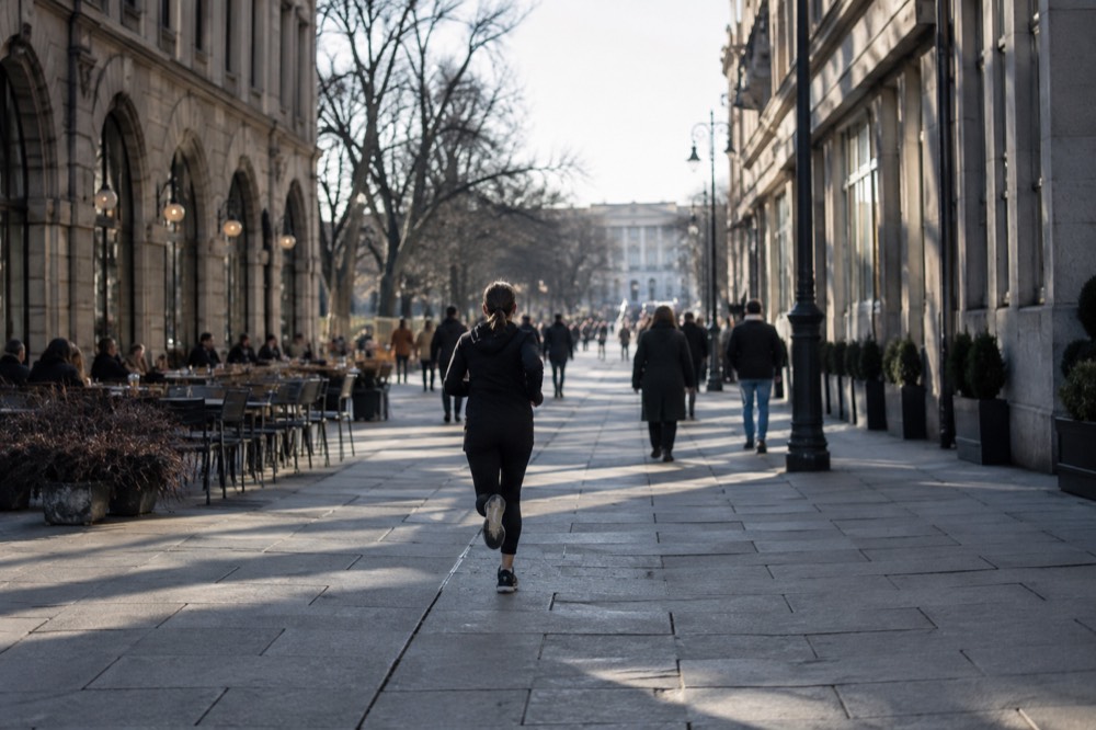 Pedestrian street with outdoor cafe tables and historic buildings on both sides