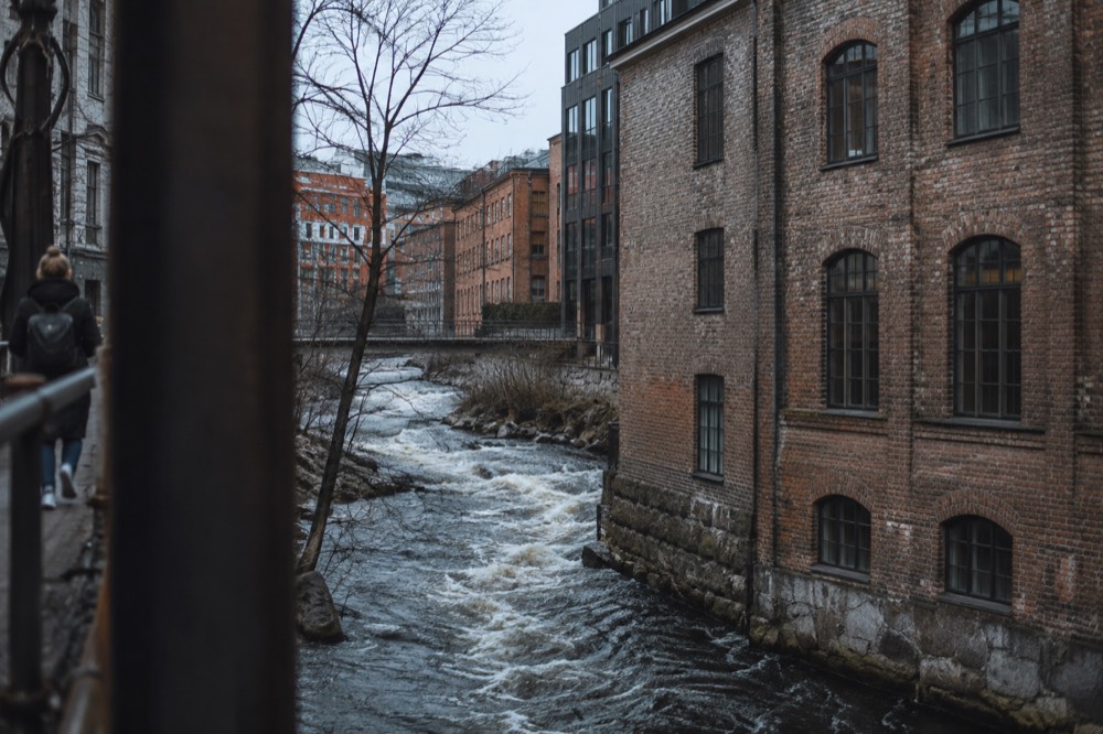 Akerselva river rushing past old brick mill buildings in Oslo