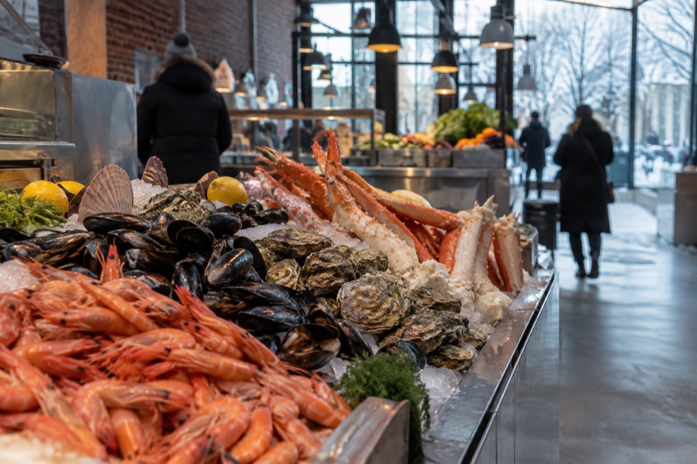 Close view of a seafood counter with shellfish on ice inside a food hall