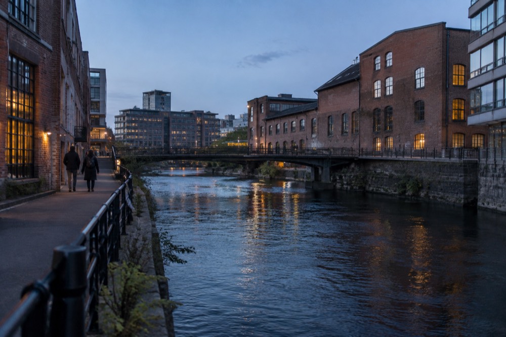 Red brick industrial buildings along a river in Oslo at dusk