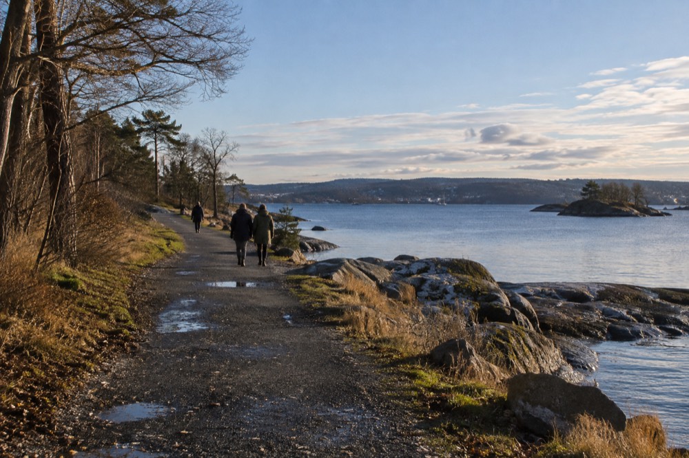 Visitors walking the coastal path on the Bygdøy peninsula with the Oslofjord behind