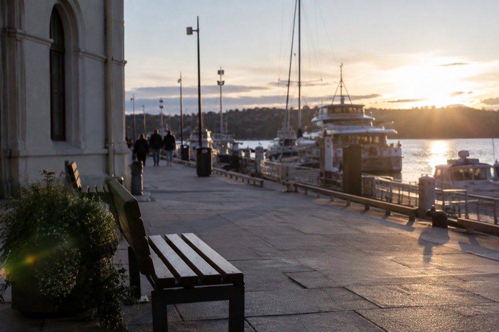 The waterfront promenade outside the museum in late evening light with boats moored along the pier