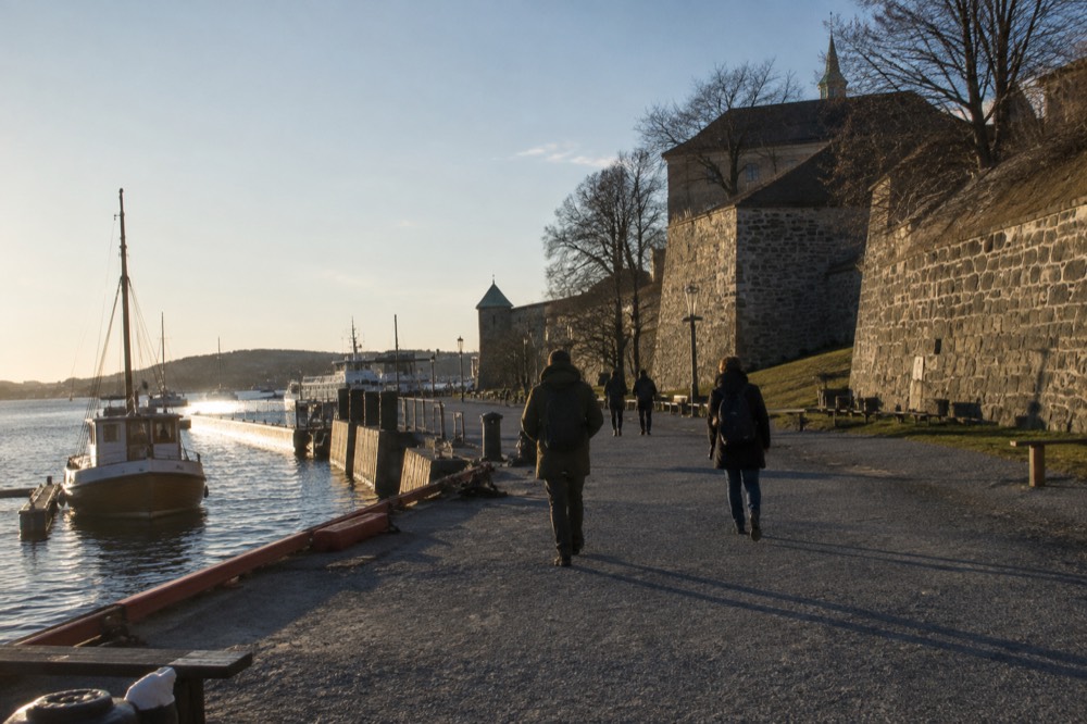 The harbor promenade between the City Hall pier and the fortress walls in afternoon light