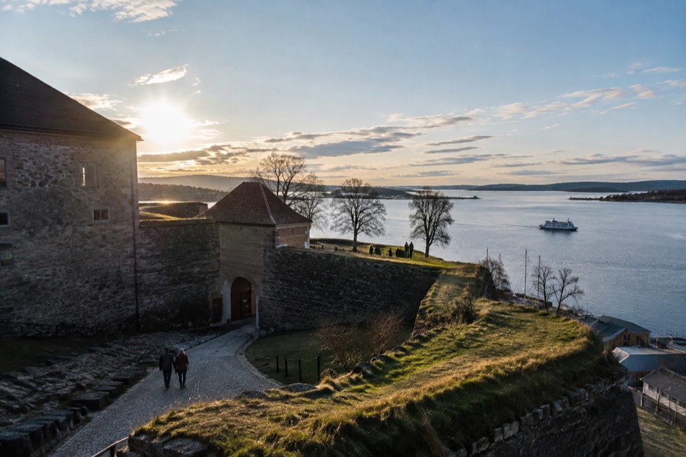 Stone walls and green ramparts of Akershus Fortress above the Oslofjord on a clear day