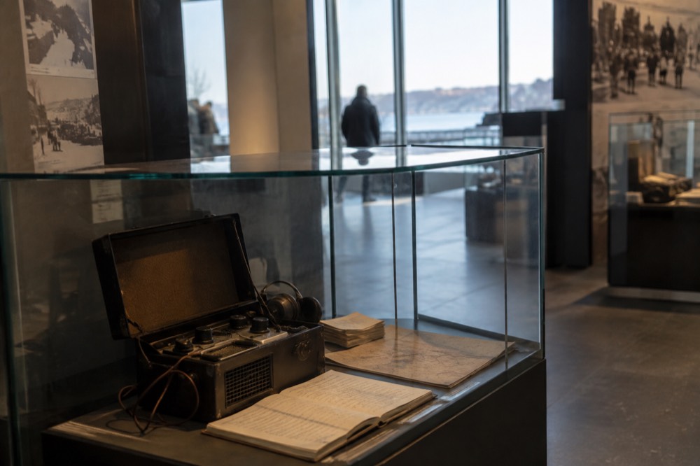 A glass display case holding a concealed wartime radio and handwritten documents