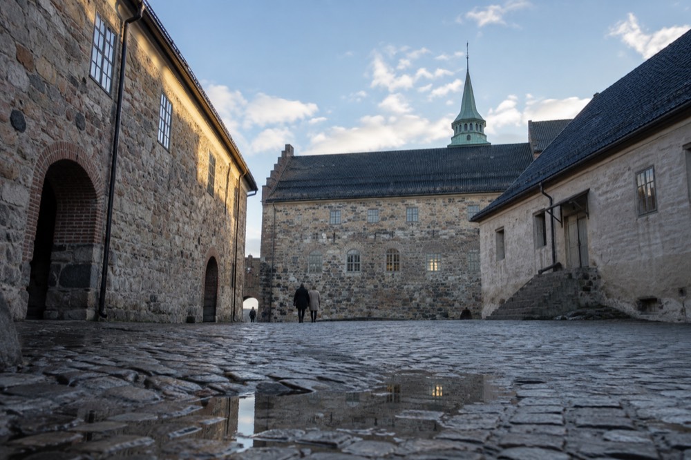 A quiet cobblestone courtyard inside the fortress with historic stone buildings on three sides