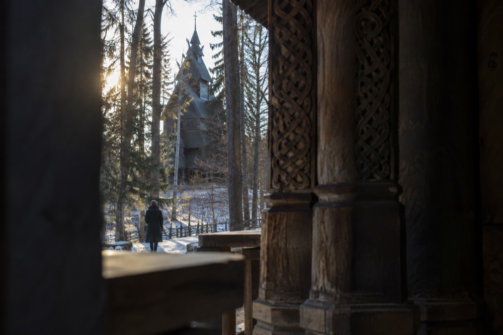 Dark timber interior of a medieval stave church with carved wooden pillars